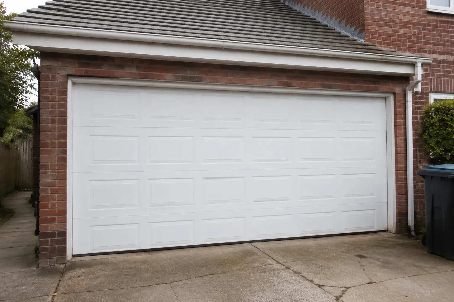 Closed white sectional garage door at an ordinary brick house. — Sectional Garage Door Replacement, East Gwillimbury